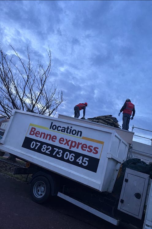 Camion ampliroll de Location Benne Expresse chargeant une benne, logo et numéro 07 82 73 06 45 peints sur le flanc